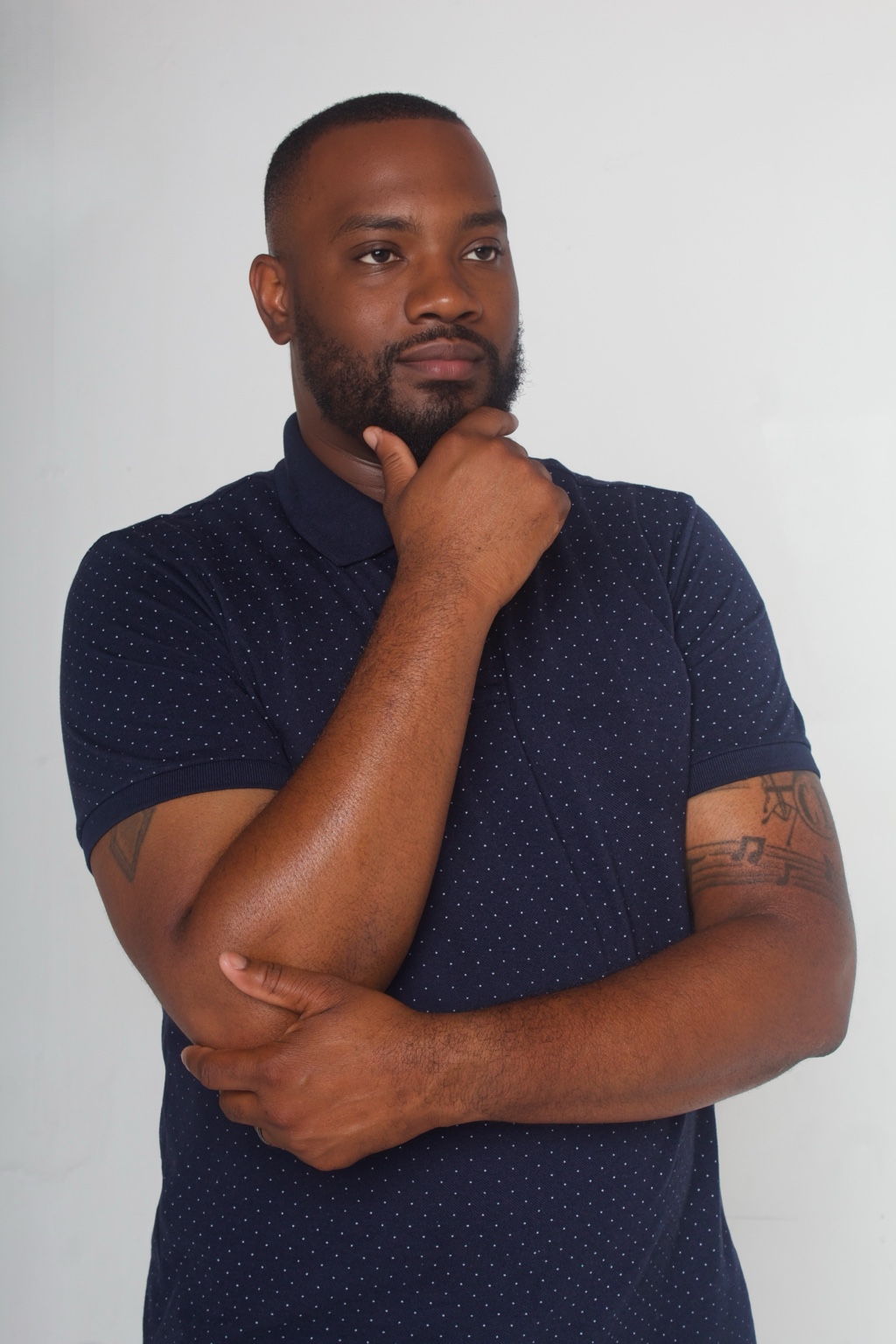 Man in a navy polo shirt photographed against a light background