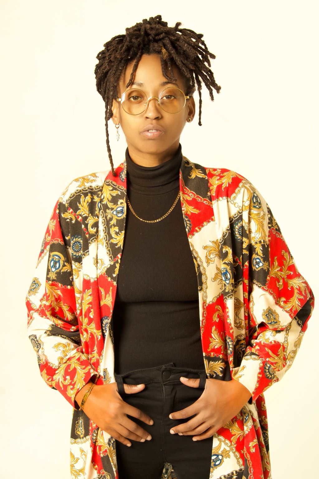 Ki in a colorful patterned jacket against a light studio background